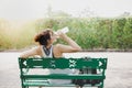 Beautiful woman feel tried and thirsty, itÃ¢â¬â¢s sunny day. Charming beautiful girl sit on bench at park and take a rest, feel